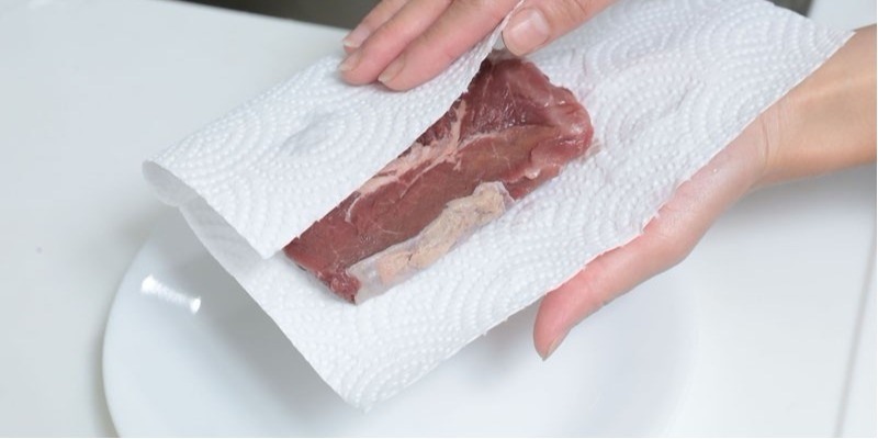 Dùng giấy ăn thấm khô nước trên thực phẩm trước khi chiên